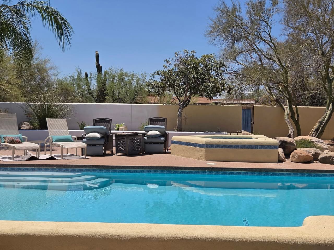 After: long block wall with an even finished surface beside a pool