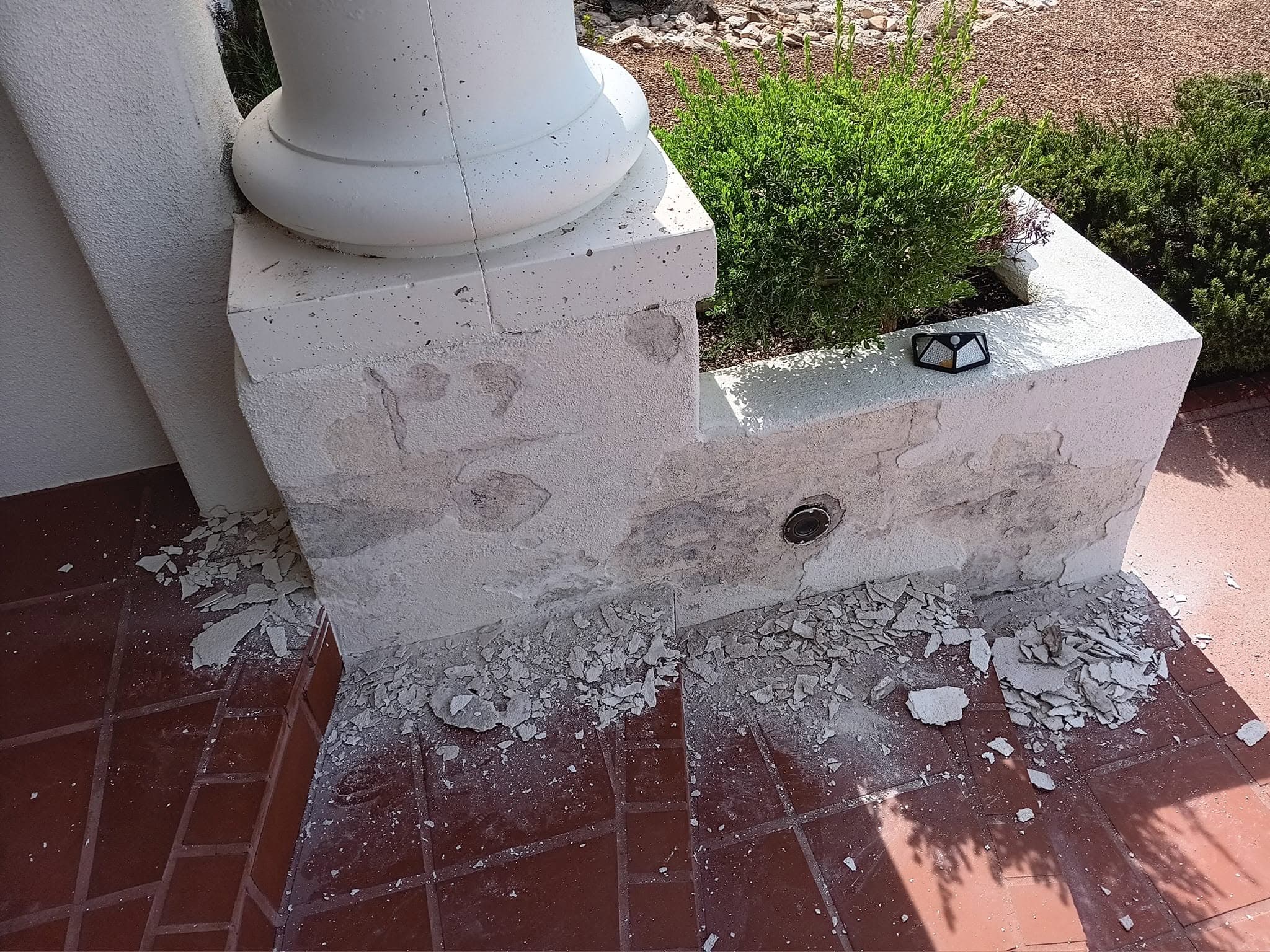 Before: deteriorated finish around the base of a residential entry wall